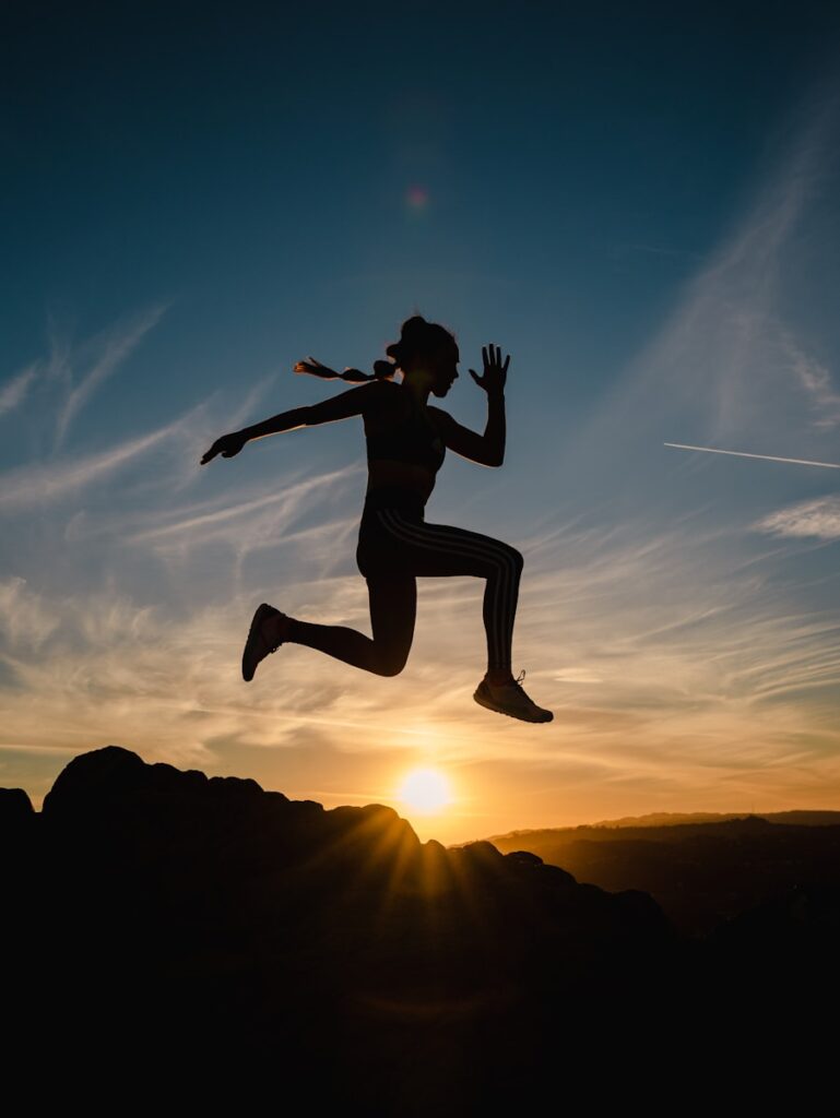 a silhouette of a person jumping in the air